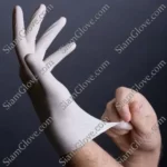 Latex glove being put on hand, disposable medical glove for protection and hygiene.
